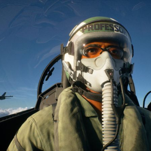 Fotografía de un piloto dentro de la cabina de un avión de combate, con otro jet volando a distancia sobre un cielo despejado.