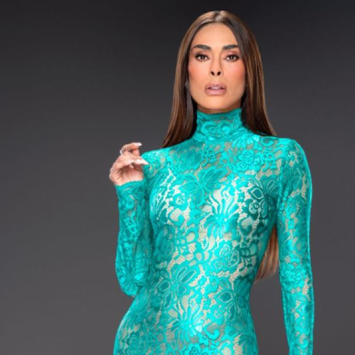 Fotografía de una persona posando en estudio con un vestido largo turquesa de encaje, en fondo neutro.