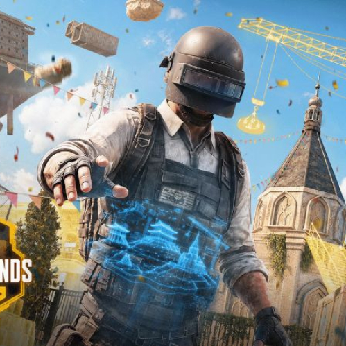 Arte promocional del concurso PUBG BATTLEGROUNDS UGC Contest. En el centro aparece un personaje icónico de PUBG con casco de nivel 3 y guantes, proyectando con la mano un mapa holográfico azul con edificios. De fondo se observa un escenario de construcción en la selva con grúas amarillas, estructuras flotantes, confeti y un templo clásico. En la esquina inferior izquierda se muestra el logotipo dorado del certamen.