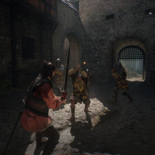 Tres combatientes armados se enfrentan en un patio medieval de piedra iluminado por luz natural.
