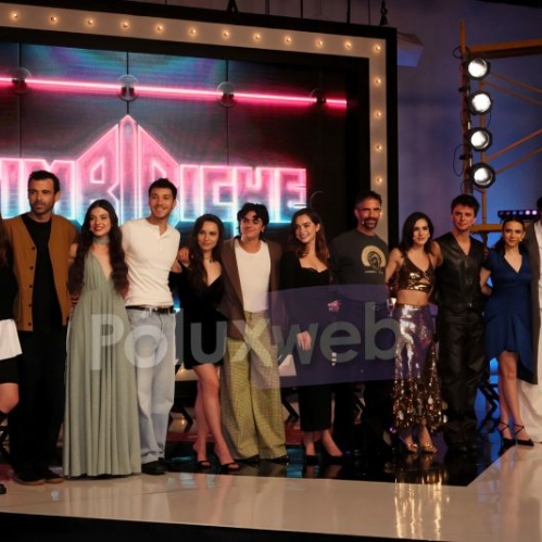 Elenco juvenil y producción de la serie Timbiriche posando juntos en el escenario durante la conferencia de prensa frente al logotipo del programa.