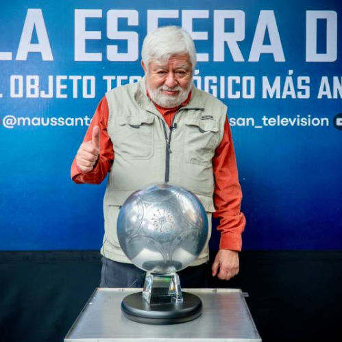 Fotografía de Jaime Maussan posando junto a una esfera metálica colocada sobre un pedestal, con un fondo azul que anuncia su presentación pública.