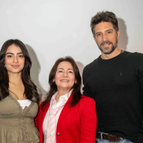 Fotografía de tres personas posando frente a un fondo claro en un entorno de presentación o anuncio.