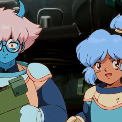 Dos personajes animados con trajes futuristas conversan en un entorno tecnológico.