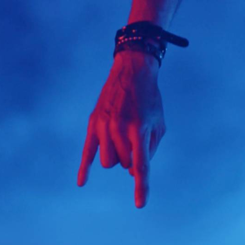 Primer plano de un brazo extendido hacia abajo sobre un fondo azul, acompañado del nombre de la banda y el título del lanzamiento.