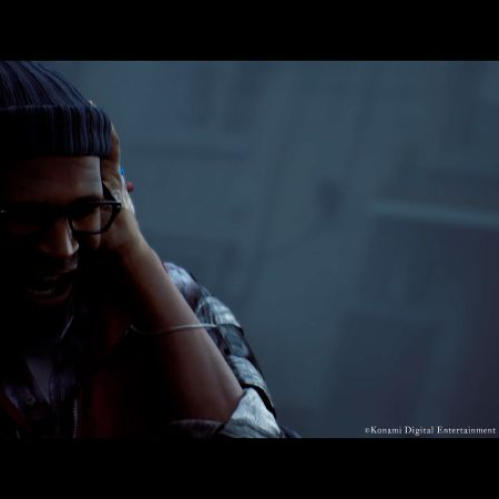 Captura del tráiler de SILENT HILL: Townfall en resolución 4K. Un hombre de tez morena (Simon Ordell) viste un gorro azul de lana, lentes de armazón negro y una camisa a cuadros. Se encuentra gritando angustiado mientras se cubre las orejas con ambas manos con fuerza, envuelto en una atmósfera oscura, húmeda y con niebla pesada de fondo.