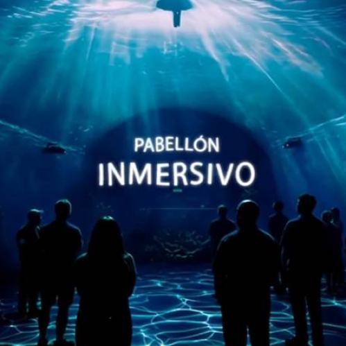 Personas dentro de un espacio oscuro iluminado por proyecciones azules que simulan un entorno acuático, creando una atmósfera inmersiva.