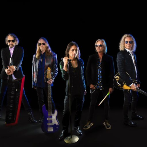 Fotografía promocional de una banda de rock posando con instrumentos sobre fondo oscuro.
