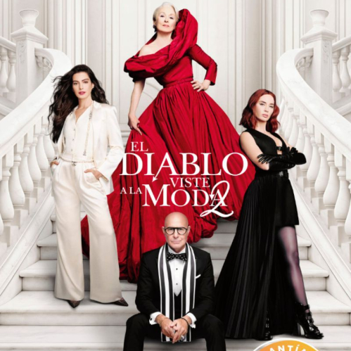 Cuatro personas posando en una escalera blanca con vestuarios elegantes.
