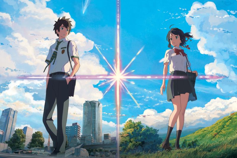 Póster del reestreno por el 10º aniversario de "Your Name.". Ilustración publicitaria en formato horizontal del póster oficial de "Your Name.". La imagen está dividida por un destello vertical de luz estelar. A la izquierda, sobre el horizonte urbano de edificios de Tokio, aparece Tatsuya (Taki) con uniforme escolar de camisa blanca, corbata y mochila al hombro. A la derecha, sobre la colina verde de Itomori con cielo azul, se encuentra Mitsuha luciendo su uniforme escolar y el tradicional listón rojo en el cabello.