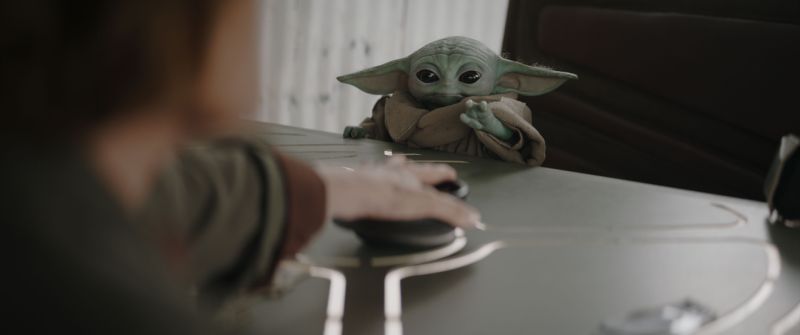 Grogu protagoniza nuevas aventuras en Star Wars Grogu observa atentamente mientras interactúa con un dispositivo en una escena de la película “Star Wars: The Mandalorian and Grogu”.