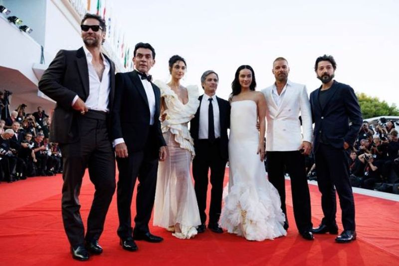 Elenco de "Hombre al Agua" en la alfombra roja del Festival Internacional de Cine de Venecia. Elenco y equipo de producción de la película "Hombre al Agua" posando sobre la alfombra roja del Festival Internacional de Cine de Venecia. De izquierda a derecha aparecen Manuel García-Rulfo, Jorge Salinas, Débora Nascimento, Gael García Bernal, Esmeralda Pimentel, Ricky Martin y Diego Luna vestida la mayoría en trajes de etiqueta y vestidos de gala en tonos blanco y negro.