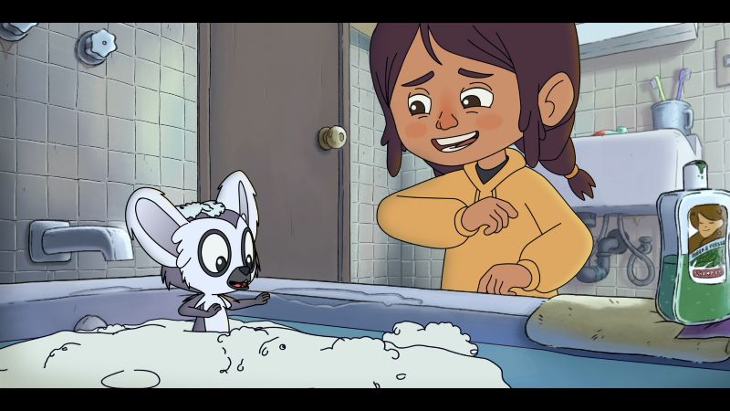 Momento cómico en el baño – Bem Niño inclinado sobre una bañera llena de espuma donde un pequeño lémur aparece sorprendido.