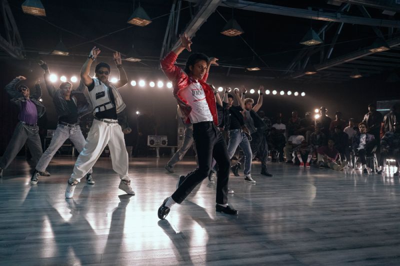 Recreación de Thriller – Michael Persona con vestuario rojo rodeada de bailarines caracterizados como zombis.