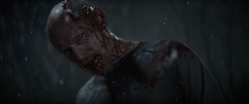 Un personaje poseído aparece cubierto de sangre bajo una intensa lluvia durante una de las secuencias del filme.