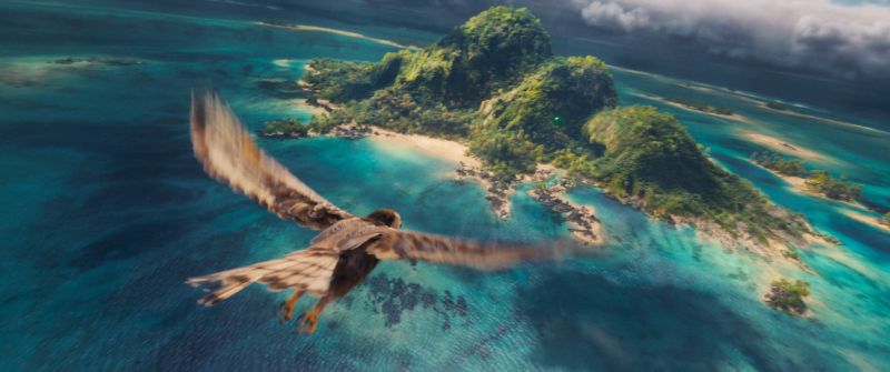 Un ave sobrevuela una isla tropical rodeada de aguas turquesa.