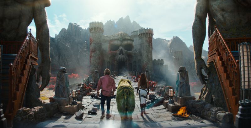 Grupo caminando hacia castillo con fachada de calavera.