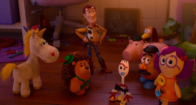 Varios juguetes reunidos en un cuarto infantil sobre un piso de madera.