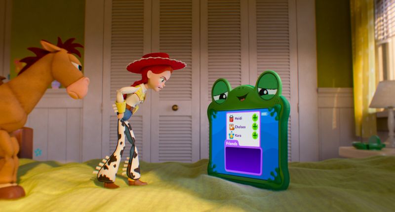 Jessie y Tiro al Blanco frente a un dispositivo verde con lista de contactos.