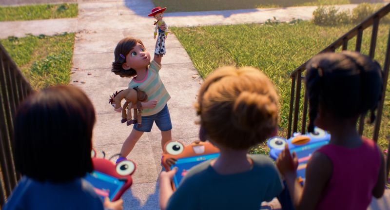 Niños jugando al aire libre con juguetes y dispositivos electrónicos.