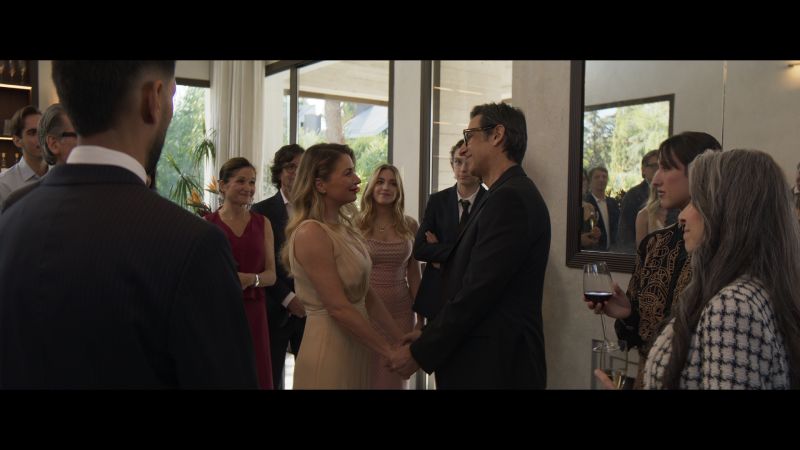 Fotograma del filme Deseo donde se observa a los personajes de Ludwika Paleta y José María Yazpik tomados de las manos en una reunión social elegante.