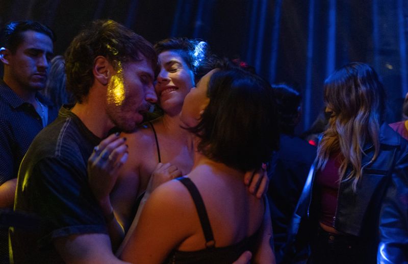 Club nocturno — La vida es Grupo de personas interactuando en un ambiente nocturno iluminado en azul y amarillo.