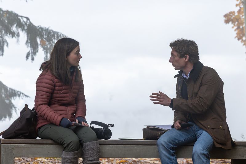 Diálogos Clave en la Trama Mikey Madison y Jeremy Allen White conversando sentados en una banca al aire libre bajo un ambiente nublado.