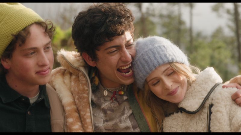 Los personajes de Mía y Martín sonriendo y abrazándose afectuosamente al aire libre durante su viaje.