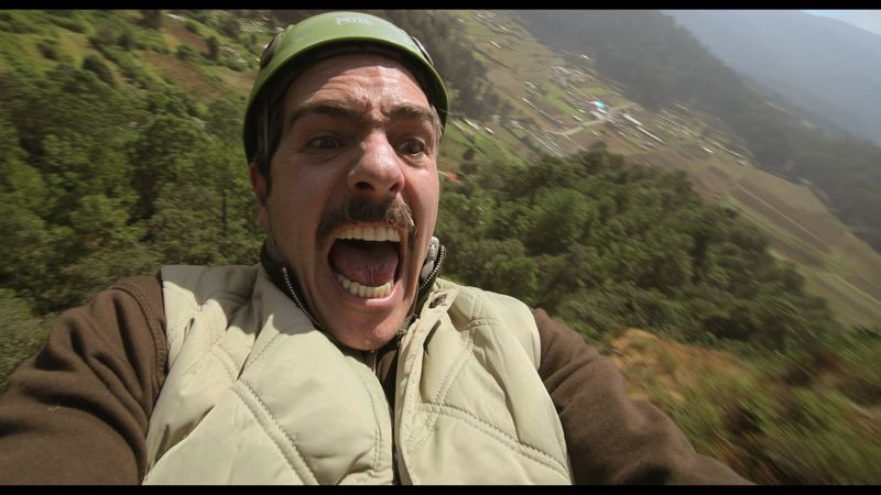 Mauricio Ochmann gritando de emoción o miedo mientras viste un casco y arnés lanzándose por una tirolesa.