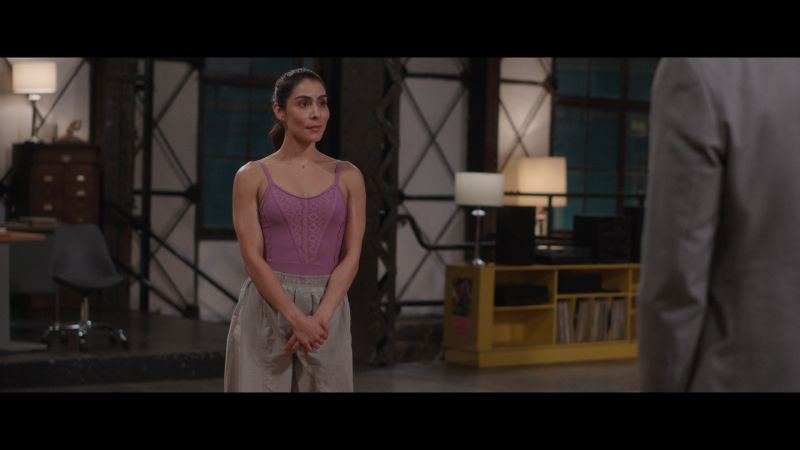 María León como Paulina Ramírez en la academia de baile Paulina Ramírez (María León) vestida con ropa deportiva rosa en el estudio de baile mirando de frente con serenidad a un interlocutor.