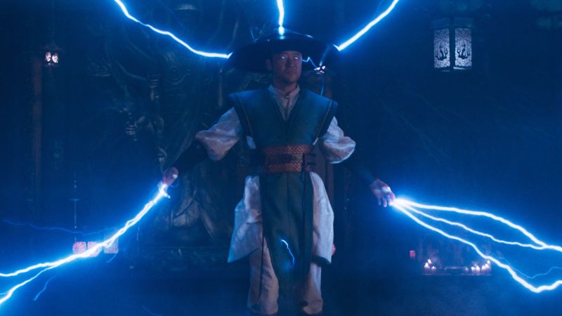 Mortal Kombat II — Poder eléctrico Personaje con sombrero tradicional liberando descargas eléctricas en un salón místico.