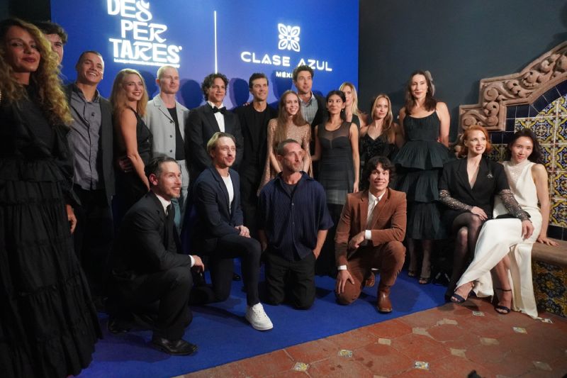 Fotografía de prensa del elenco internacional de la gala de danza Despertares posando frente a un fondo azul con los logotipos del evento. Bailarines y creativos vestidos de gala sonríen de pie y en cuclillas para la toma oficial.