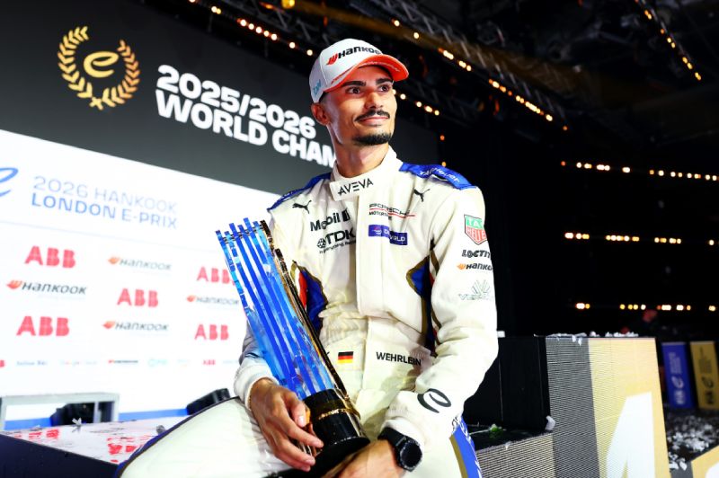 Pascal Wehrlein celebra el Campeonato Mundial de Formula E 2026 Fotografía del piloto Pascal Wehrlein vistiendo su uniforme de careras blanco y azul con gorra mientras sostiene el trofeo del campeonato mundial frente a un fondo del evento.