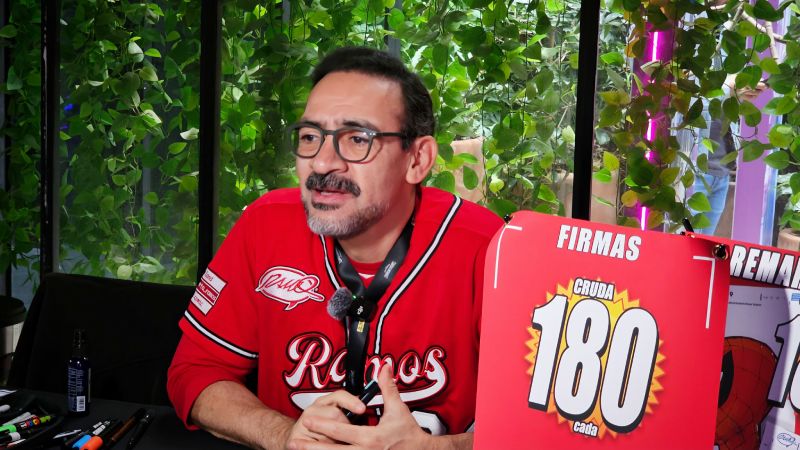 El reconocido dibujante de Spider-Man, Humberto Ramos, sonriendo en su mesa de autógrafos con un letrero de firmas durante la Experiencia Panini 2026.