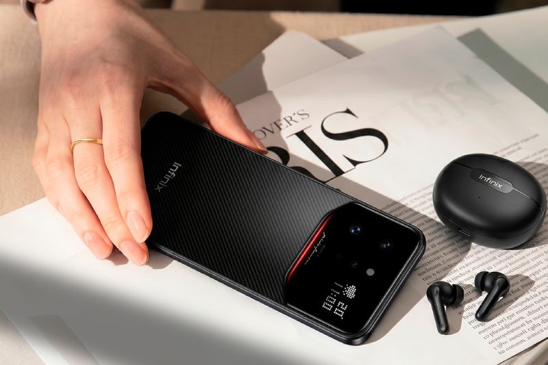Vista posterior del smartphone Infinix NOTE 60 Ultra 5G con acabado en textura de Kevlar, mostrando el módulo de cámara uni-chasis de vidrio con el logo de Pininfarina, el Display de Matriz Activa con ícono de clima y hora, junto a unos audífonos inalámbricos Infinix.