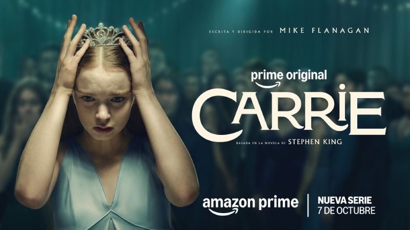 Arte promocional oficial de la serie. En el centro, la actriz Summer H. Howell en el papel de Carrie White viste un vestido azul claro de tirantes con cuello en V. Sostiene con ambas manos una tiara o corona plateada sobre su cabeza, luciendo el cabello rubio peinado hacia atrás. Su rostro muestra una expresión de angustia, shock y concentración mirando fijamente hacia abajo. Al fondo, un grupo de estudiantes de preparatoria en ropa formal de baile se aprecian fuera de foco. En el costado derecho se lee en tipografía crema "prime original CARRIE basada en la novela de STEPHEN KING" con la fecha de estreno "NUEVA SERIE 7 DE OCTUBRE".