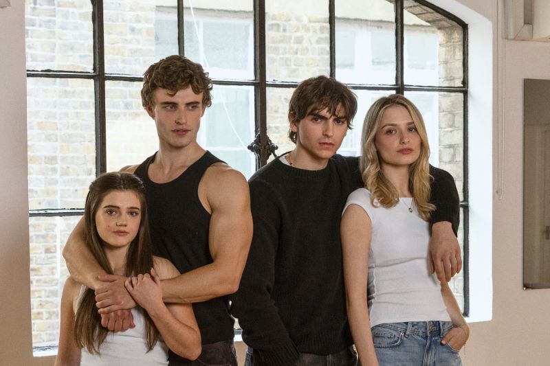 Elenco principal de Boys of Tommen – Prime Video Cuatro jóvenes posan juntos en un espacio interior iluminado por una gran ventana.