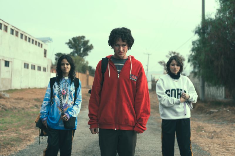 Los tres protagonistas juveniles caminando por una calle de tierra, liderados por Diego Bernal en el centro con chamarra roja.