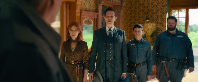 Grupo de personajes representando a las inteligencias artificiales JARVIS, FRIDAY y E.D.I.T.H. en trajes elegantes dentro de una casa.