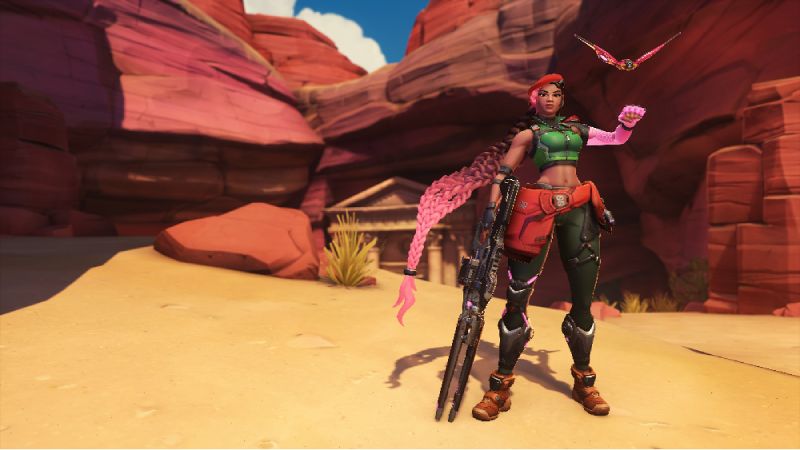 Sierra en la Temporada 2 de Overwatch Personaje femenino armado en un entorno desértico con estética futurista, acompañada de un dron flotante.