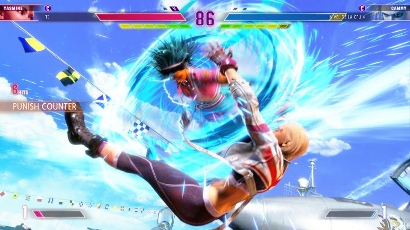 Yasmine ejecutando un Punish Counter contra Cammy Captura de pantalla de combate aéreo en la que Yasmine conecta un Punish Counter en pleno aire sobre Cammy sobre un escenario con barcos y cazas militares.