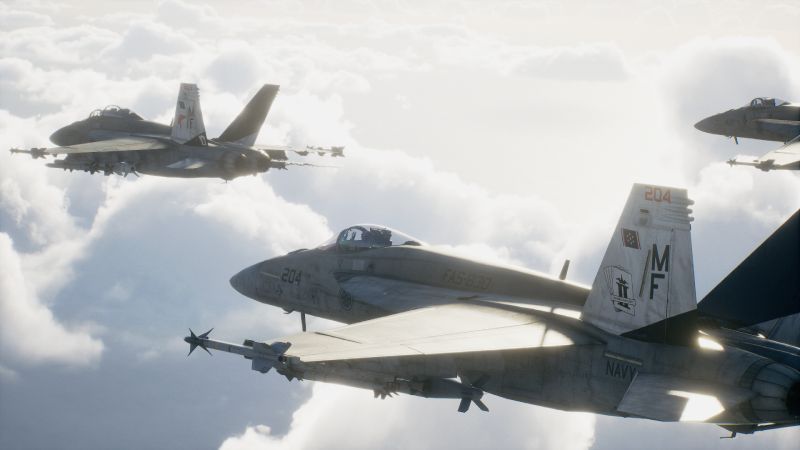 Ace Combat 8 – Formación aérea Formación de aeronaves militares volando sobre un mar de nubes iluminado por la luz del sol.
