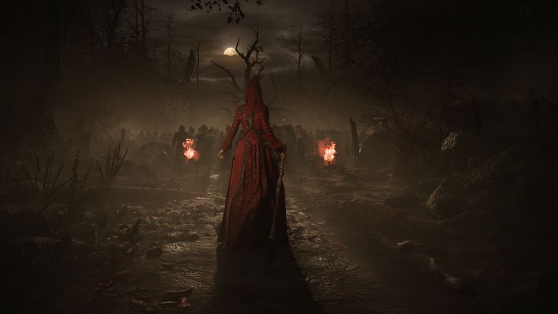 Figura encapuchada con capa roja avanza por un sendero oscuro rodeado de niebla, con antorchas encendidas y siluetas humanas al fondo.