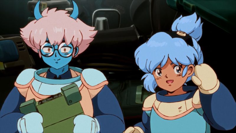 “Orbitals” – Arte promocional Dos personajes animados con trajes futuristas conversan en un entorno tecnológico.