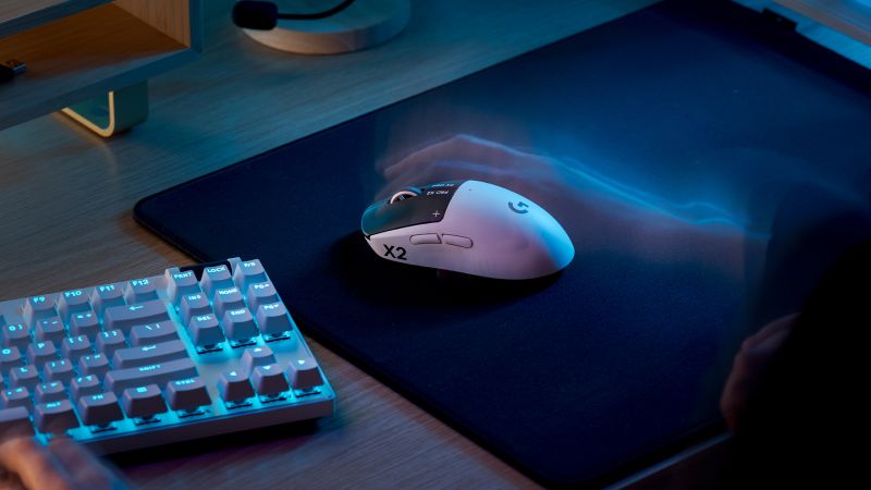 Mouse y teclado de gaming sobre un escritorio de madera, con iluminación fría y un diseño orientado al rendimiento competitivo.