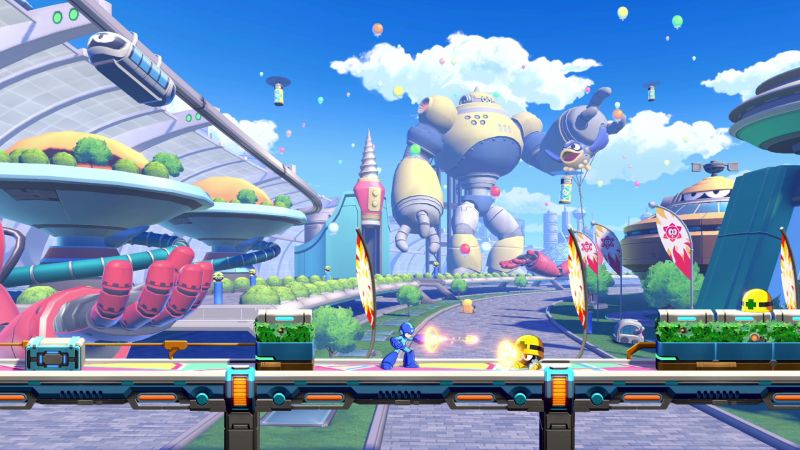 Mega Man disparando a un enemigo en un escenario colorido al aire libre con un enorme robot de fondo y globos en el cielo.