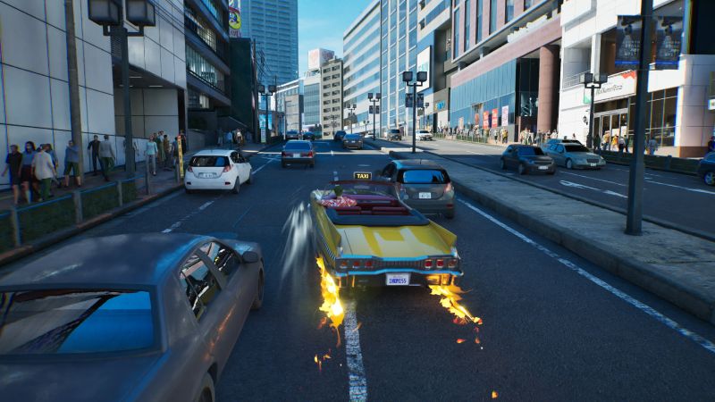 Derrape en el mapa de Japón de Crazy Taxi World Tour Captura de pantalla de jugabilidad en tercera persona de Crazy Taxi: World Tour. Muestra un taxi convertible amarillo derrapando en una avenida asfaltada mientras saca llamas de las ruedas traseras. Alrededor hay vehículos modernos, peatones en la acera y grandes edificios comerciales en una calle urbana de Japón.