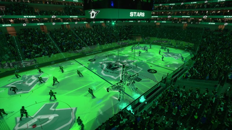 Vista aérea de la arena iluminada con proyectores de luz verde que proyectan la estrella del logo de Dallas Stars sobre la pista antes del partido.