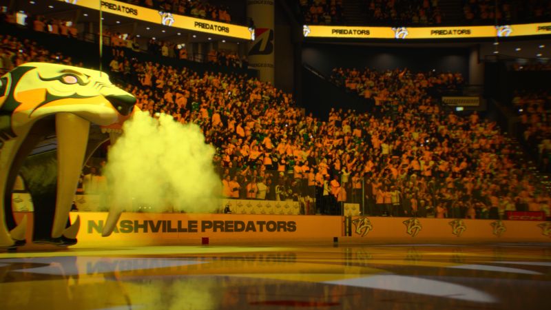 Mascota de los Nashville Predators soltando humo amarillo por la boca en la salida de los jugadores hacia la pista.