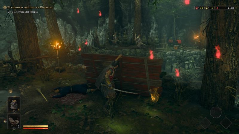 Musashi agazapado detrás de una barricada de madera en un bosque oscuro iluminado por antorchas y almas rojas flotantes, acechando a enemigos a lo lejos.